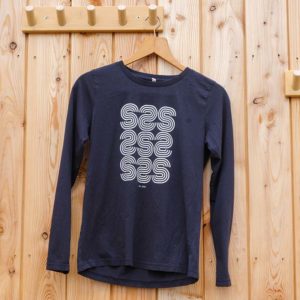 A navy blue long-sleeve shirt hangs on a wooden hanger, featuring a white geometric “S” pattern printed on the front.
